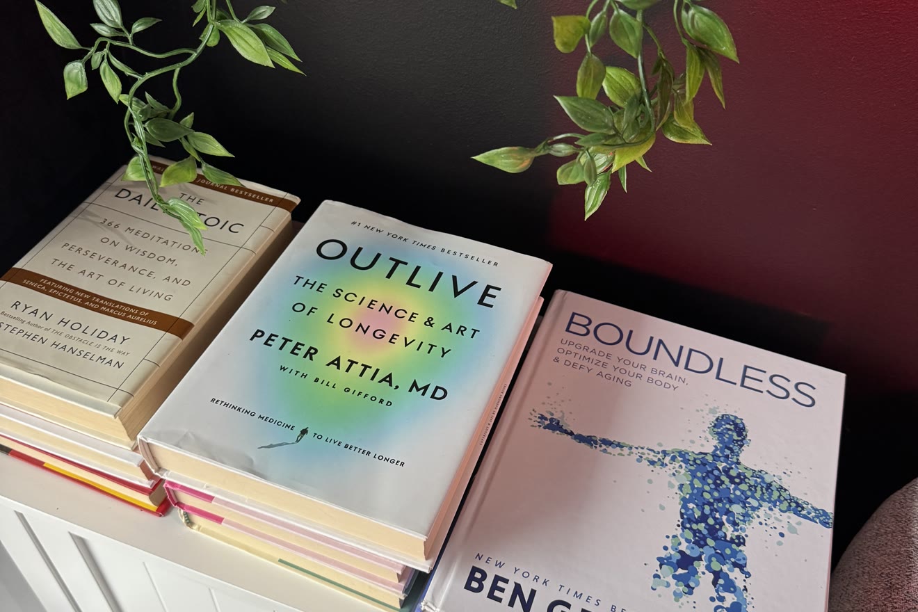 Longevity books including Outlive and Boundless on a shelf at BioHack Studios